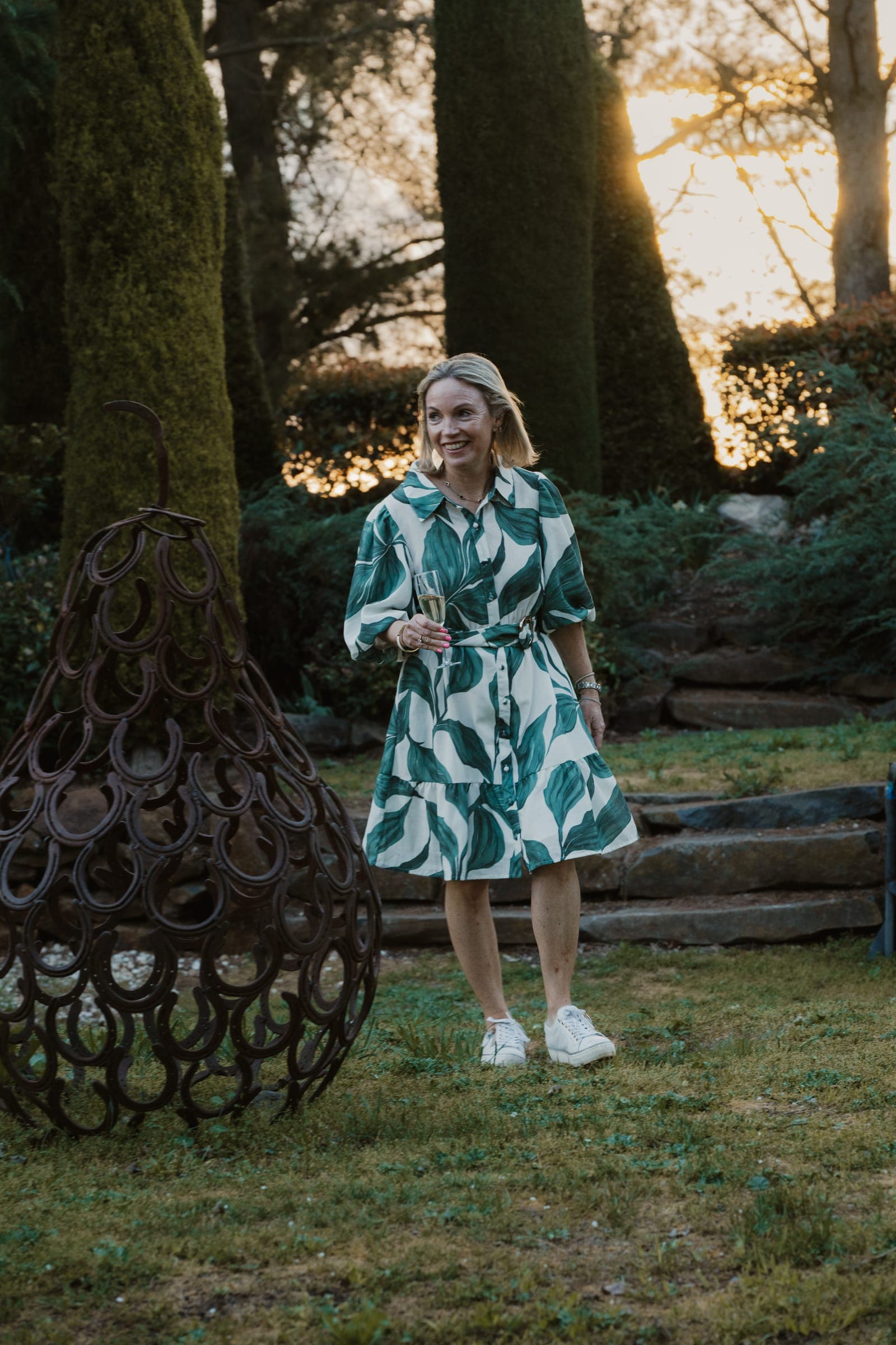 A guest beside the horseshoe pear sculpture in the garden