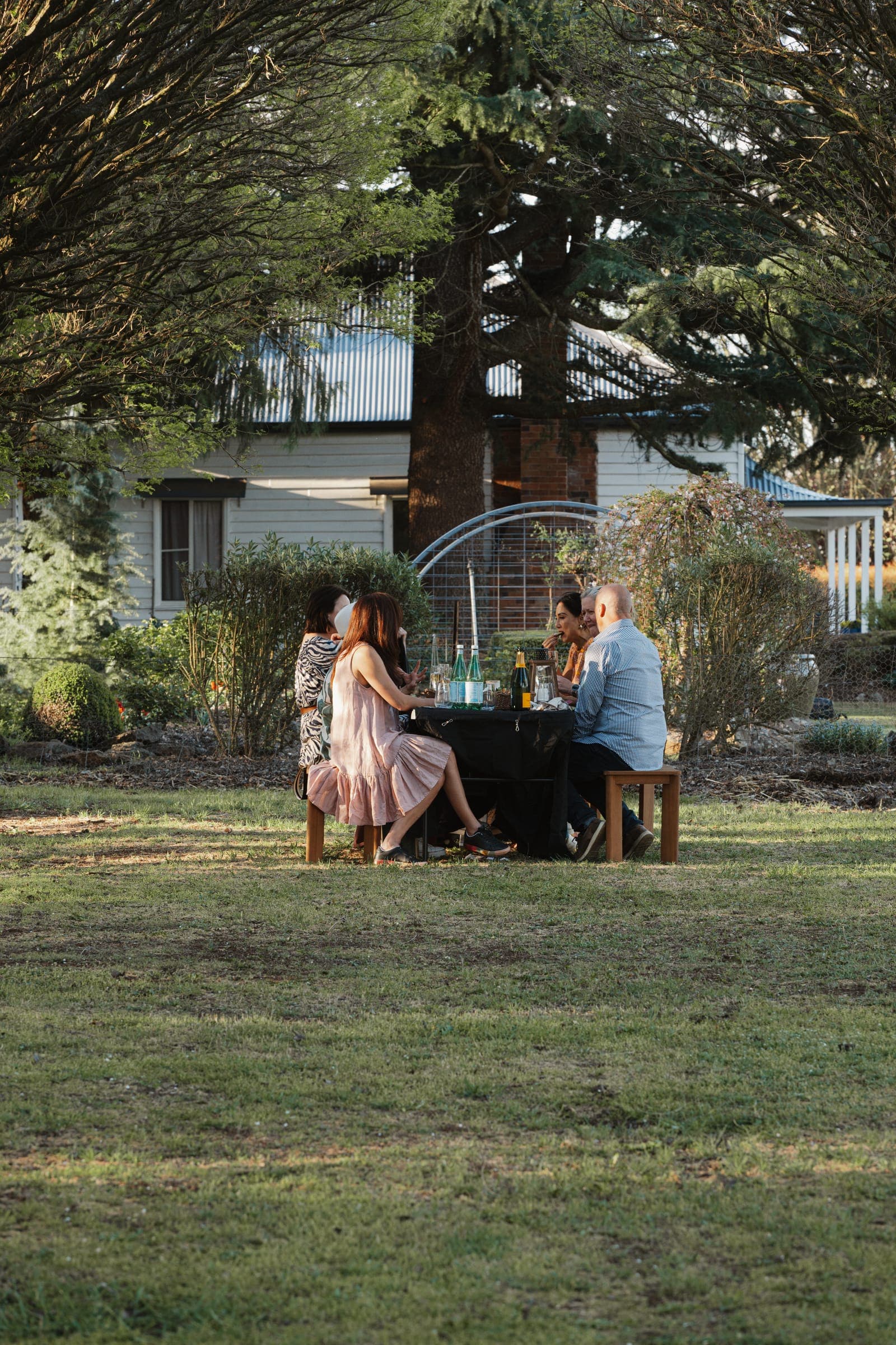 An intimate table set on the lawn in front of the farmhouse