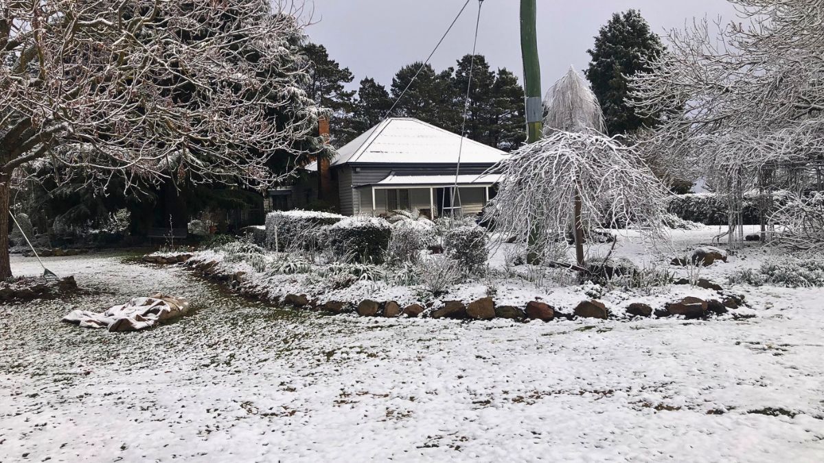 Snow falling on a farm house in New England NSW in winter time